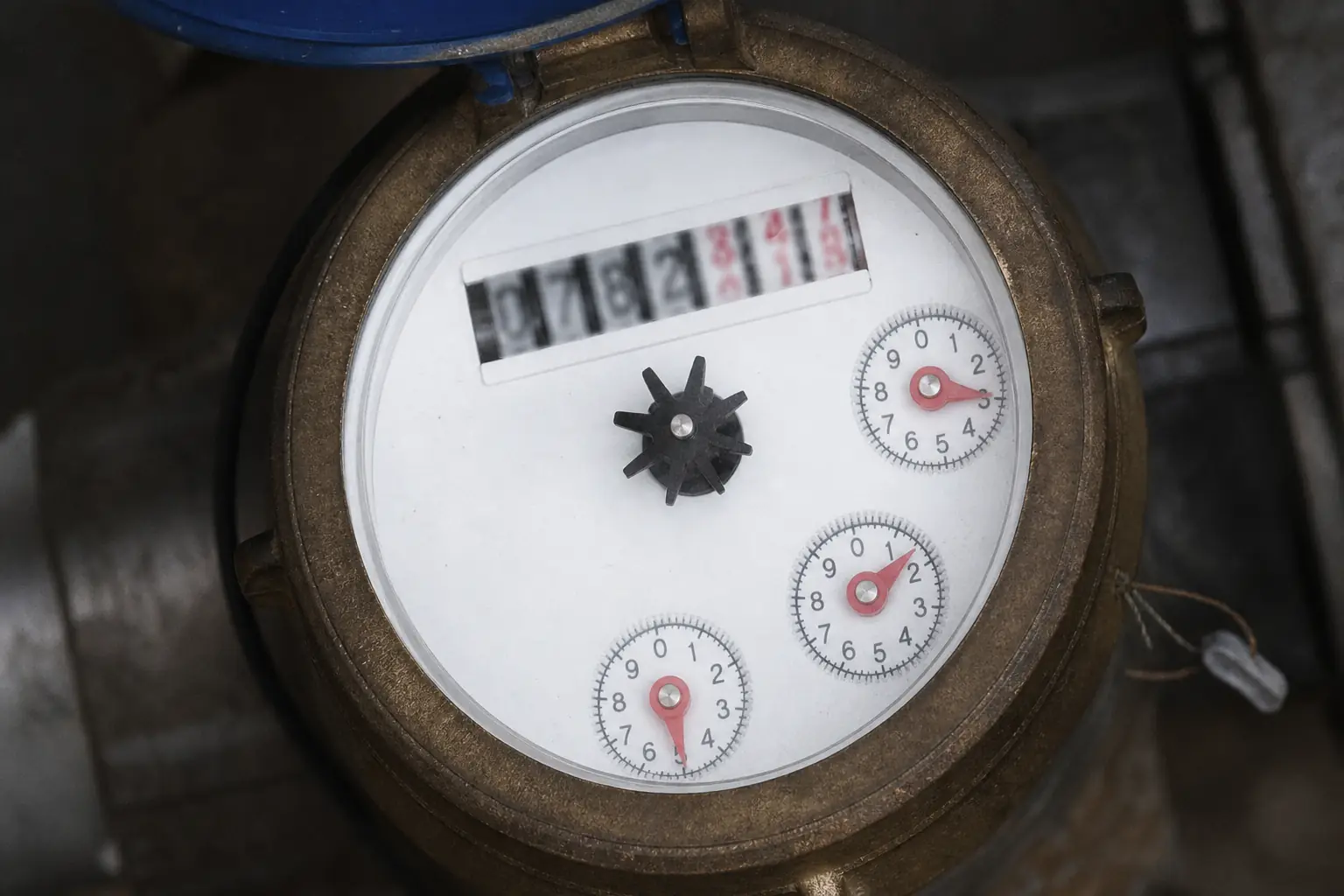 Cadran d'un compteur d'eau domestique en gros plan, aiguille de l'étoile de fuite nette